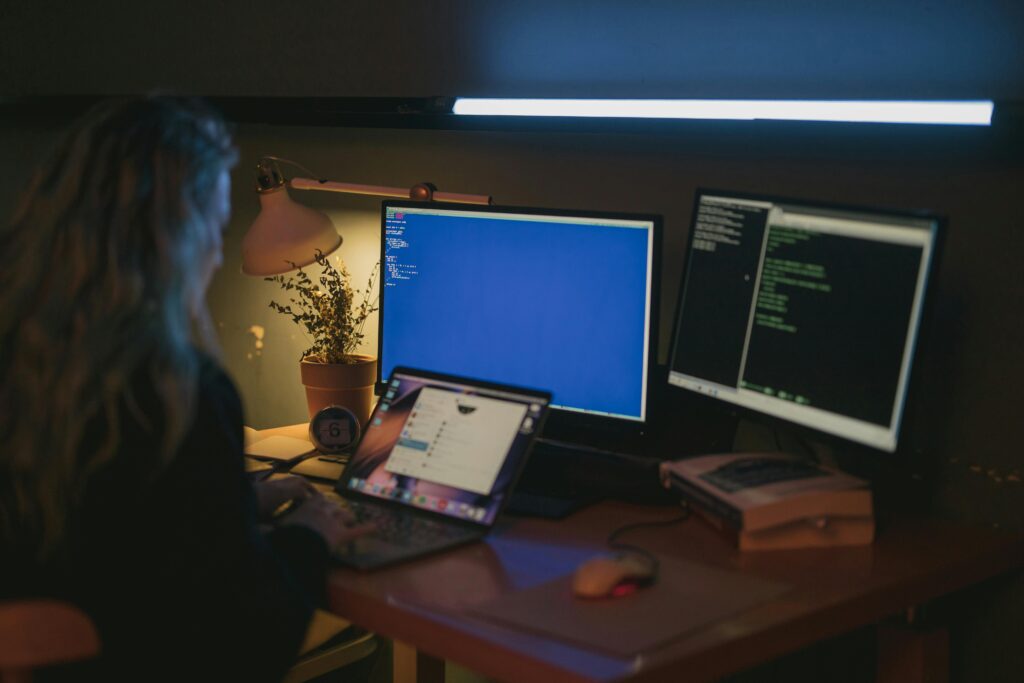 pexels-photo-5473298-5473298 Woman using multiple screens for cybersecurity tasks in a cozy home office